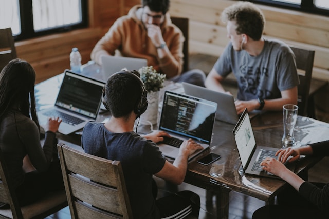 Programmers sitting on a table and coding together